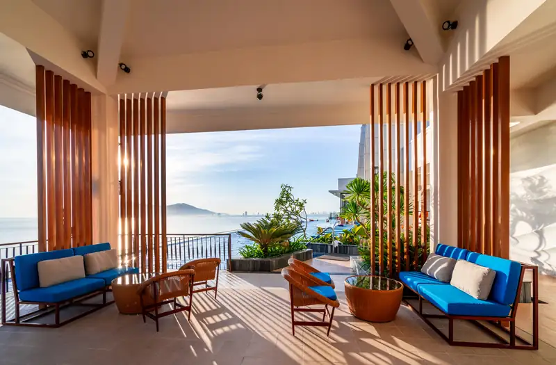 Hiên có mái che, sofa xanh nhìn ra vịnh Đà Nẵng ở khu hồ vô cực tầng 22