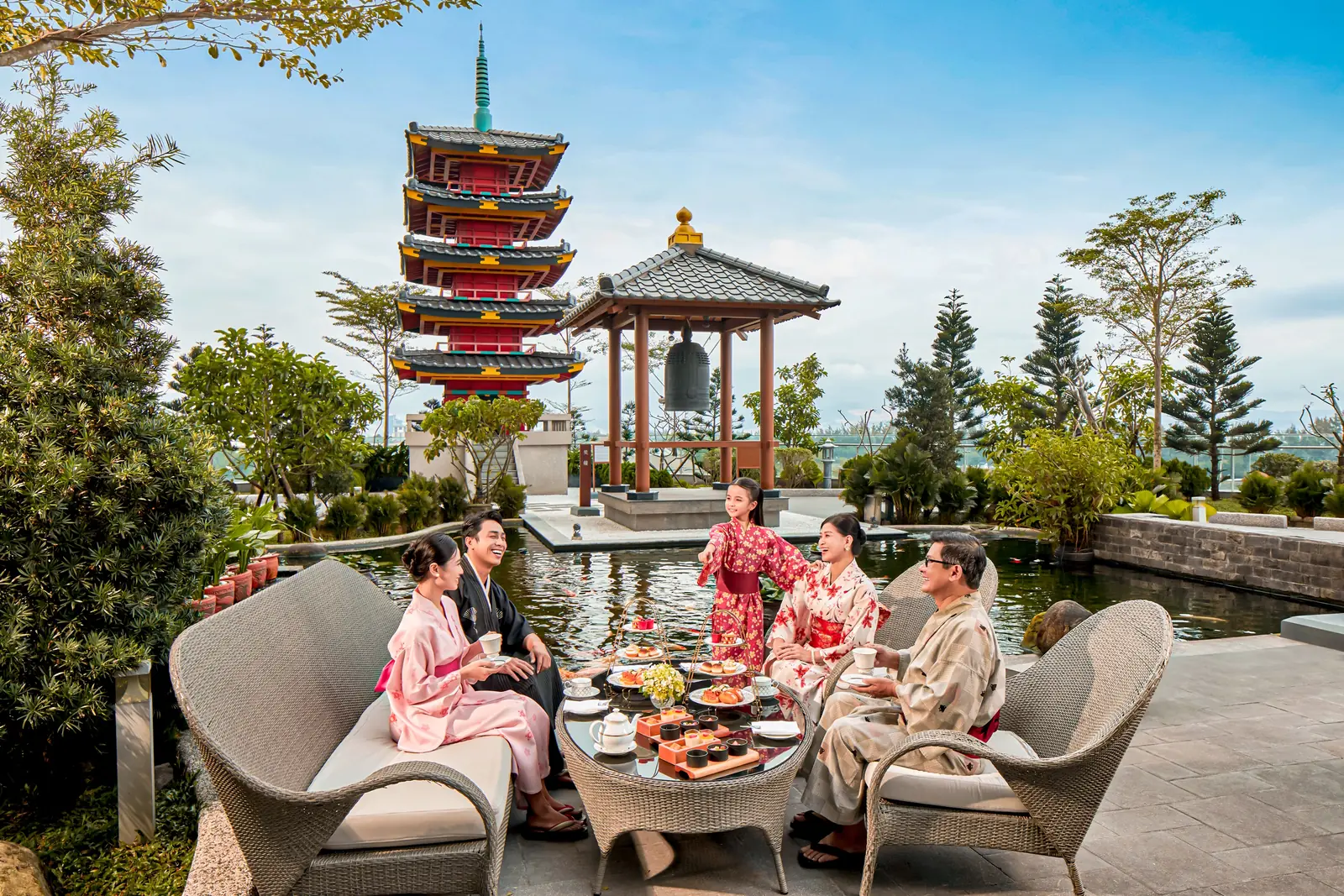 Gia đình ba thế hệ mặc yukata ngồi dùng trà chiều bên hồ cá cạnh tháp chùa 5 tầng trong vườn Nhật, Mikazuki Đà Nẵng