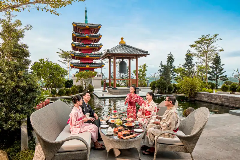 Gia đình mặc yukata dùng trà chiều cạnh tháp chùa trong vườn Nhật