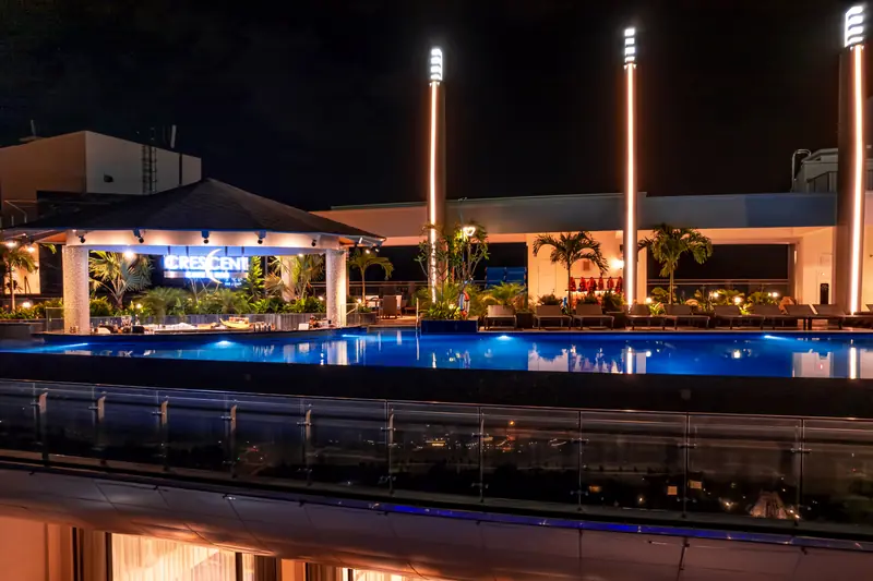 Quầy Crescent Café & Bar sáng đèn bên hồ bơi vô cực tầng 22 lúc tối, Mikazuki Đà Nẵng