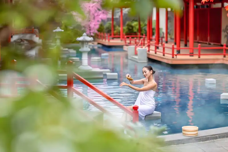Bể onsen ngoài trời bên hành lang gỗ đỏ và đèn đá kiểu Nhật ở Mikazuki Đà Nẵng