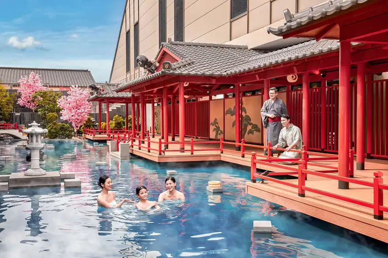 Khách ngâm bể onsen công cộng ngoài trời trước dãy nhà mái ngói kiểu Nhật ở Mikazuki Đà Nẵng
