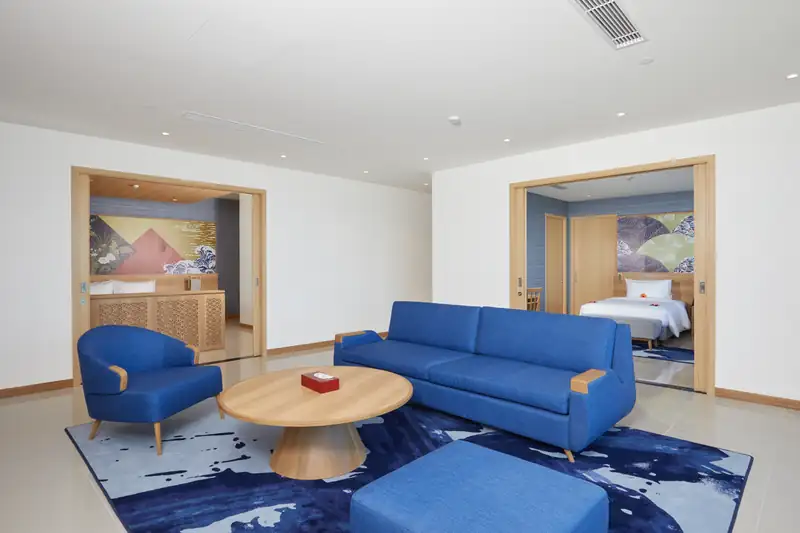 Phòng khách Ambassador Suite với sofa xanh, hai bên mở vào hai phòng ngủ riêng