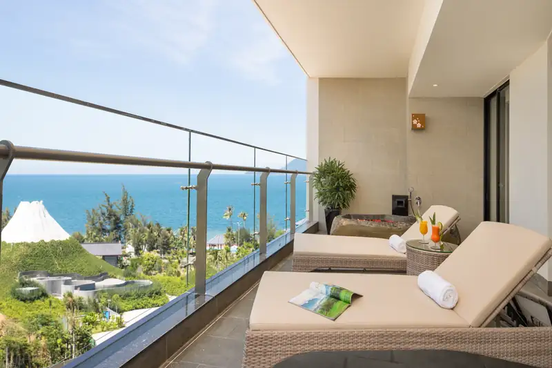 Ban công Executive Suite có ghế tắm nắng, nhìn xuống núi Phú Sĩ thu nhỏ và biển Đà Nẵng