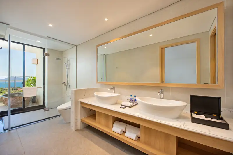 Phòng tắm Executive Suite: bồn rửa đôi, buồng tắm kính, cửa sổ nhìn biển