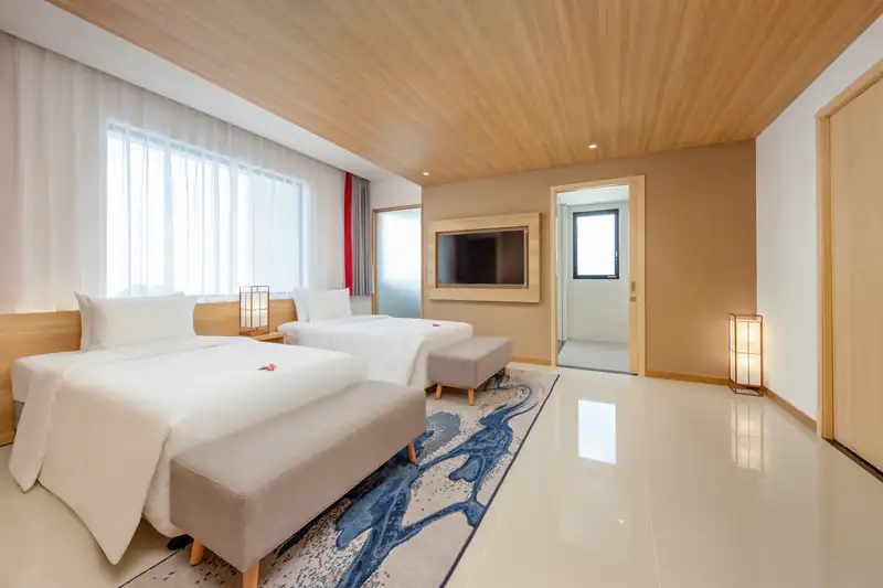Phòng ngủ thứ hai của Executive Suite: hai giường đơn, thảm hoa văn sóng xanh, Mikazuki Đà Nẵng