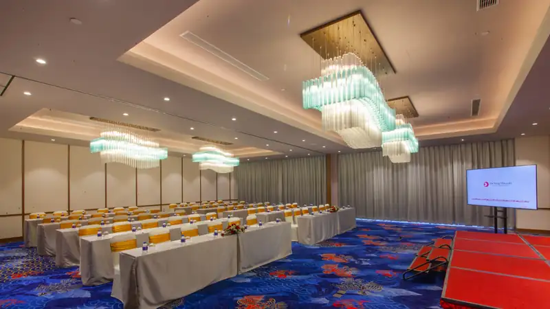 Phòng Sakura bày bàn kiểu lớp học hướng về màn hình và sân khấu nhỏ