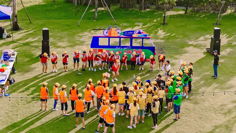 Đoàn team building chia đội theo màu áo tập trung trên bãi cỏ Fuji Lawn